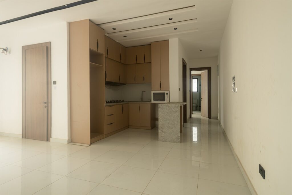 Brum Height 4: Open living space adjoining a fitted kitchen with wood-tone cabinetry